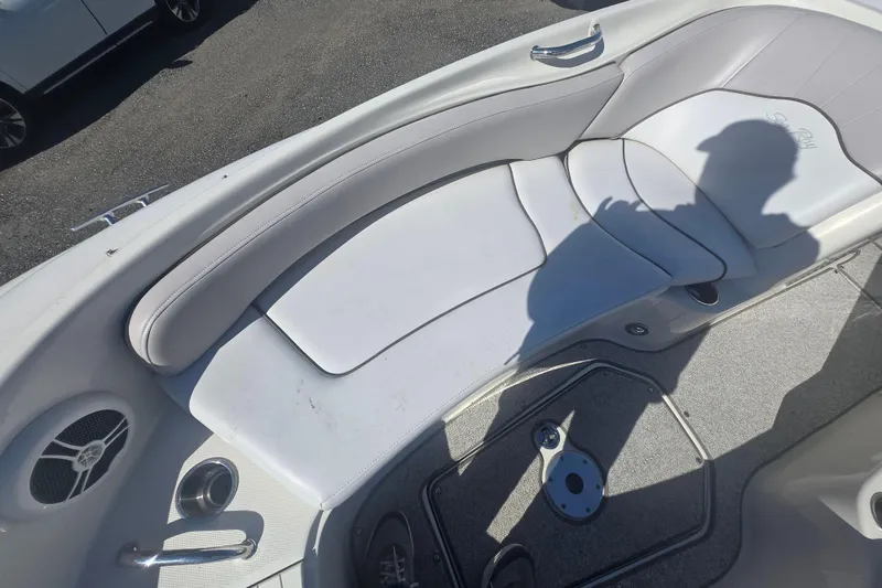Slide: The Image of 2009 Sea Ray 240 Sundeck interior with white seating and speaker detail. - 9