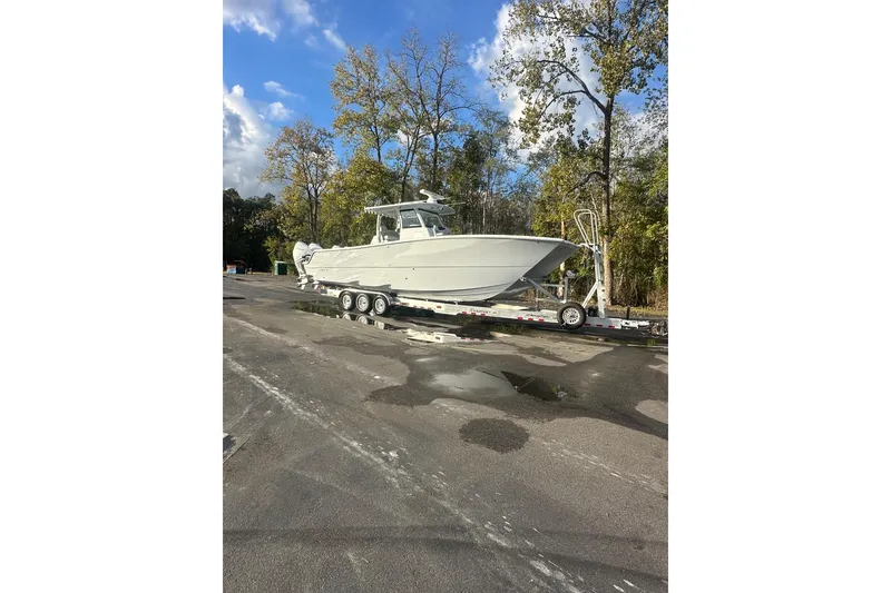 The Image of 2025 Freeman 35 boat on trailer, parked outdoors with trees and blue sky. - 0