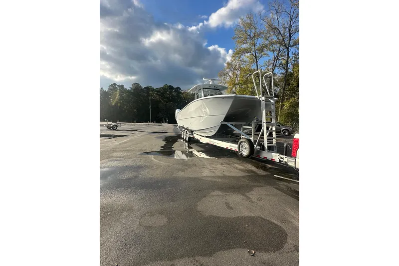 Slide: The Image of Freeman 35 boat on trailer in parking lot, 2025 model, under cloudy sky. - 2