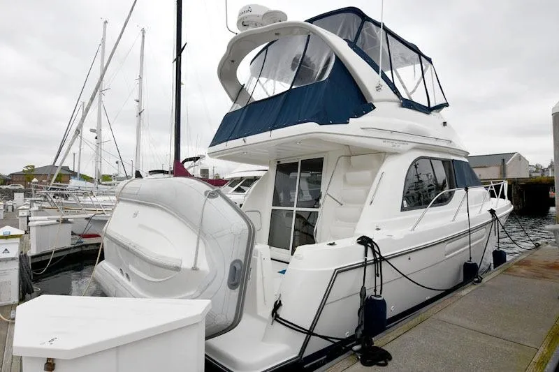Slide: The Image of 2001 Bayliner 3788 Command Bridge Motoryacht docked at marina, featuring spacious upper deck. - 1