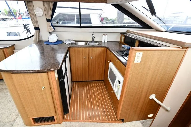 Slide: The Image of Interior of 2001 Bayliner 3788 yacht kitchen with wood cabinetry and appliances. - 11