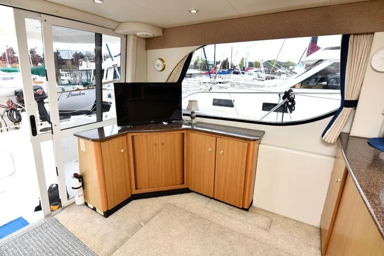Slide: The Image of Interior of 2001 Bayliner 3788 Command Bridge Motoryacht with wood cabinetry and marina view. - 8