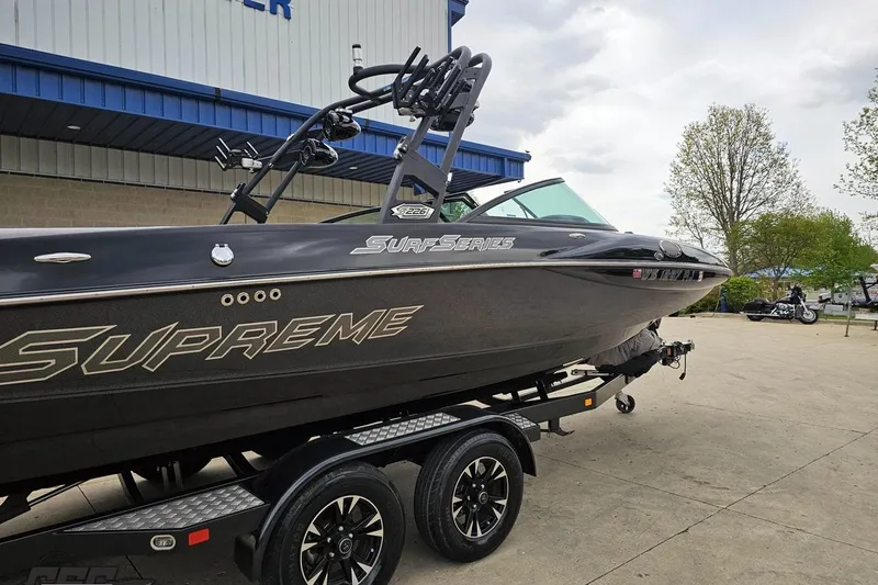 Slide: The Image of 2018 Supreme S226 boat on trailer, parked outdoors near a building. - 11