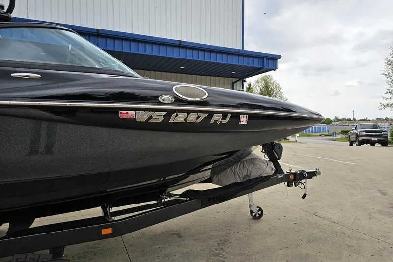 Slide: The Image of 2018 Supreme S226 boat on trailer outside a blue-roofed building. - 14