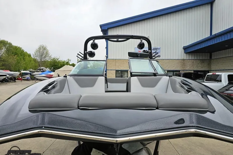 Slide: The Image of 2018 Supreme S226 boat with sleek design, parked outdoors near a building. - 18