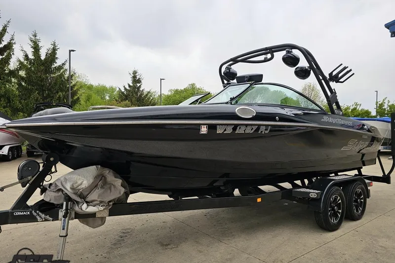 Slide: The Image of 2018 Supreme S226 boat on trailer, sleek black design, parked outdoors. - 21