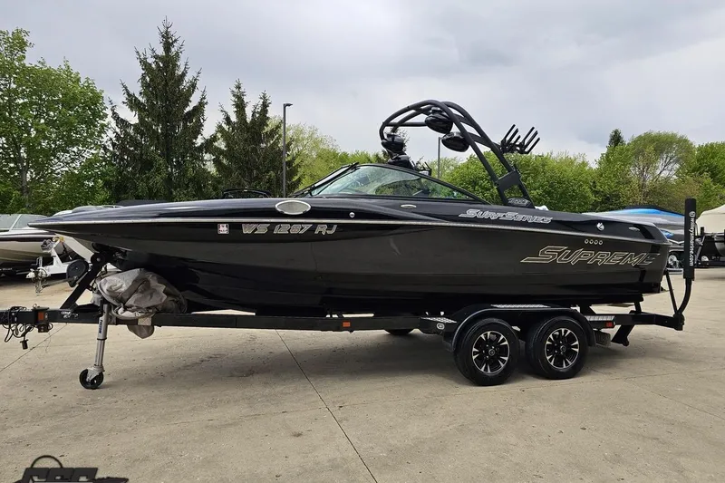 Slide: The Image of 2018 Supreme S226 boat on trailer, black exterior, parked outdoors. - 22