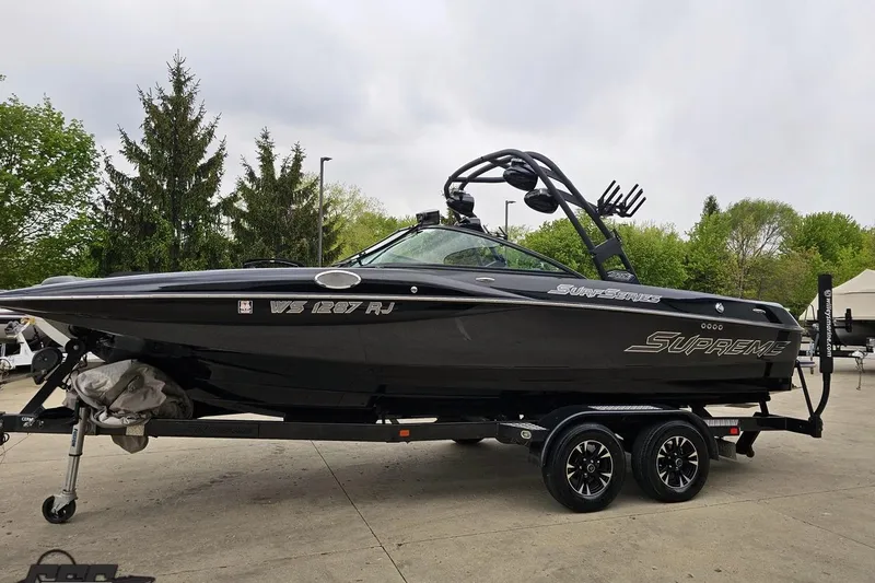 Slide: The Image of 2018 Supreme S226 boat on trailer, black exterior, parked outdoors. - 23
