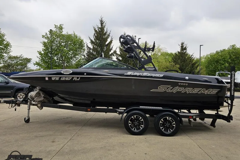 Slide: The Image of 2018 Supreme S226 boat on trailer, sleek black design, parked outdoors. - 24