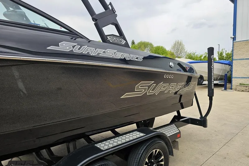 Slide: The Image of 2018 Supreme S226 Surf Series boat on trailer, showcasing sleek design and branding. - 28