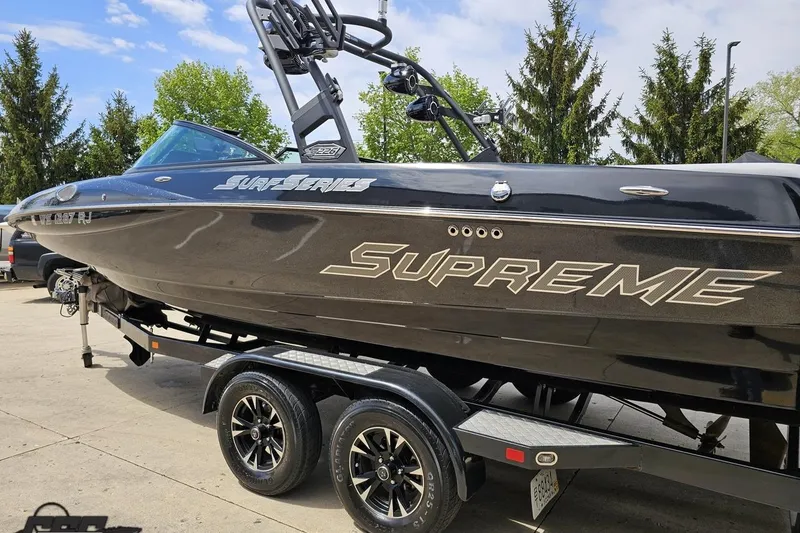 Slide: The Image of 2018 Supreme S226 boat on trailer, black exterior, "Surf Series" branding, parked outdoors. - 30