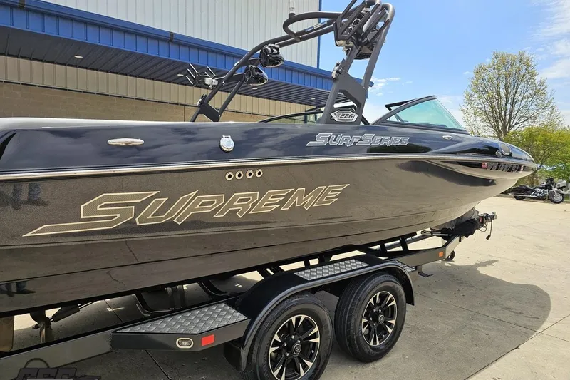 Slide: The Image of 2018 Supreme S226 boat on trailer, black exterior, parked outdoors. - 7
