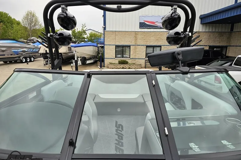 Slide: The Image of 2018 Supreme S226 boat interior with speakers and windshield, parked near other boats. - 84