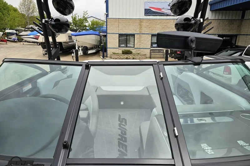 Slide: The Image of 2018 Supreme S226 boat interior with windshield, parked among other boats at a dealership. - 85