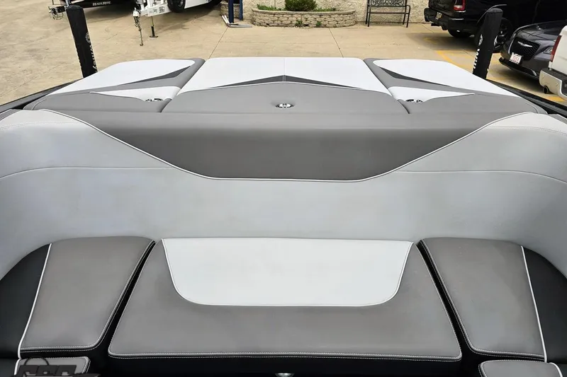 Slide: The Image of 2018 Supreme S226 boat interior with gray and white upholstery, parked outdoors. - 90