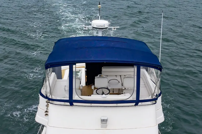 Slide: The Image of 2011 Mainship 395 Trawler with blue canopy cruising on open water. - 22