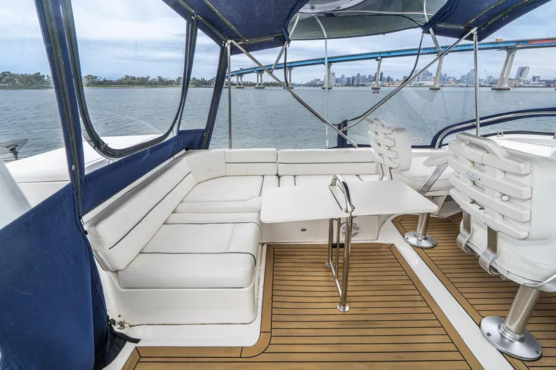 Slide: The Image of 2011 Mainship 395 Trawler interior with white seating, table, and scenic waterfront view. - 27