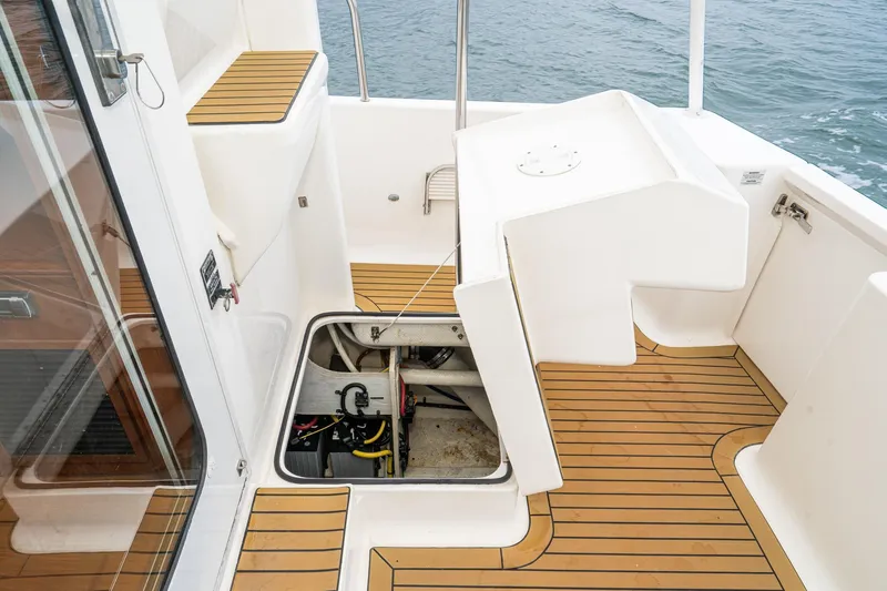 Slide: The Image of 2011 Mainship 395 Trawler deck with open hatch, revealing engine compartment. - 36