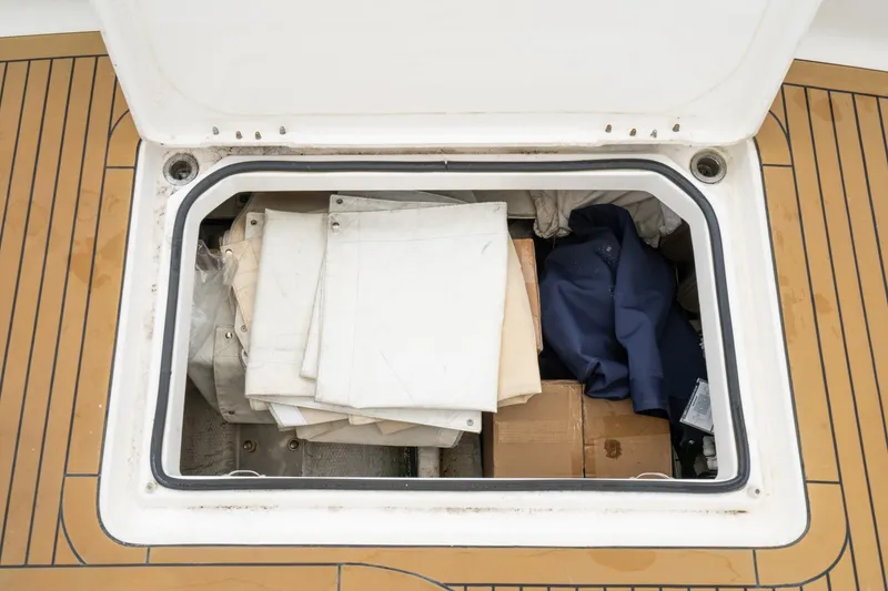 Slide: The Image of Storage compartment on 2011 Mainship 395 Trawler with folded canvas and boxes. - 37