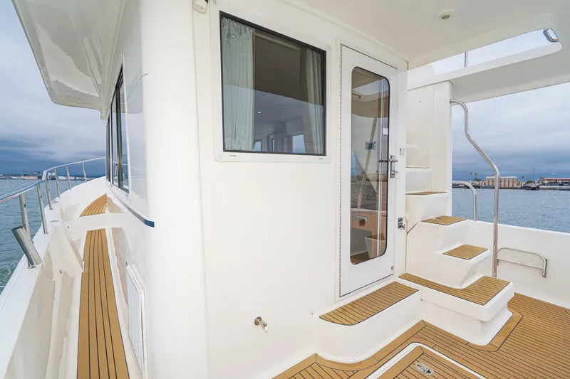 Slide: The Image of 2011 Mainship 395 Trawler deck with teak flooring and ocean view. - 39
