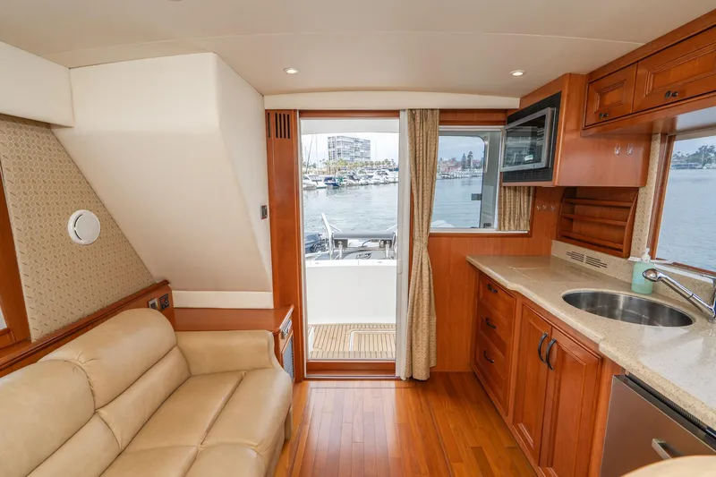 Slide: The Image of Interior of 2011 Mainship 395 Trawler with beige seating, wooden cabinetry, and waterfront view. - 44
