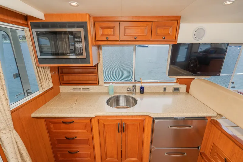 Slide: The Image of Modern kitchen in 2011 Mainship 395 Trawler with wood cabinetry, sink, and appliances. - 45