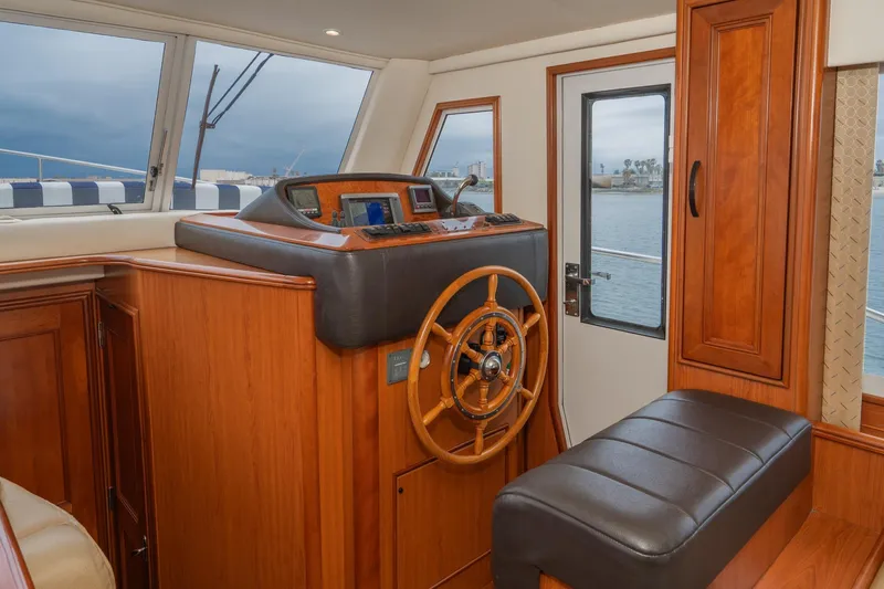 Slide: The Image of Interior helm of 2011 Mainship 395 Trawler with wooden steering wheel and navigation equipment. - 46