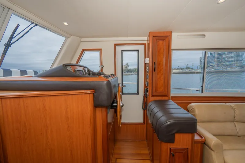 Slide: The Image of Interior of 2011 Mainship 395 Trawler, featuring helm station and comfortable seating. - 47