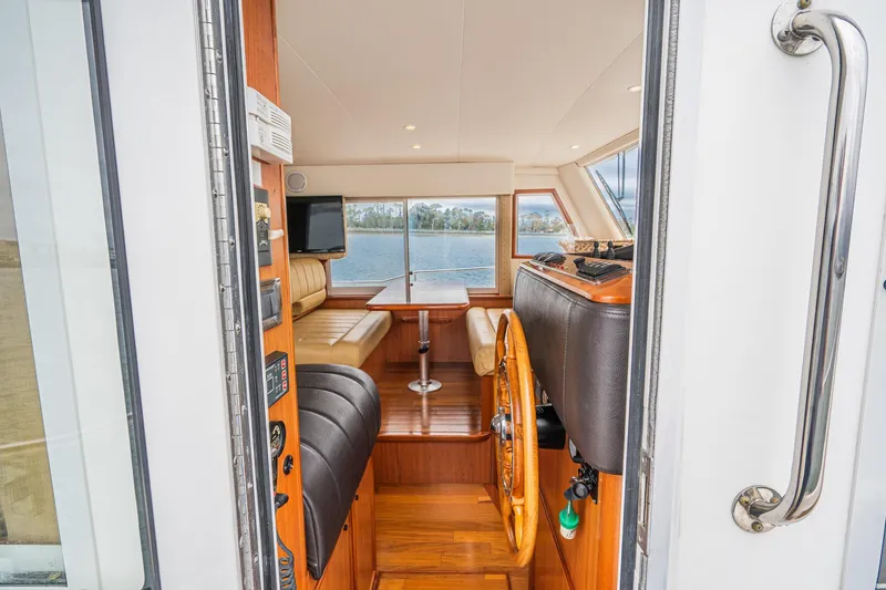 Slide: The Image of Interior view of 2011 Mainship 395 Trawler, featuring helm and seating area with water view. - 51