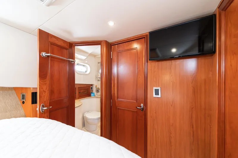 Slide: The Image of Luxurious 2011 Mainship 395 Trawler interior with wood paneling, TV, and bathroom view. - 56