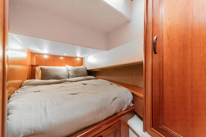 Slide: The Image of Cozy cabin interior of 2011 Mainship 395 Trawler with wooden finishes and comfortable bedding. - 57