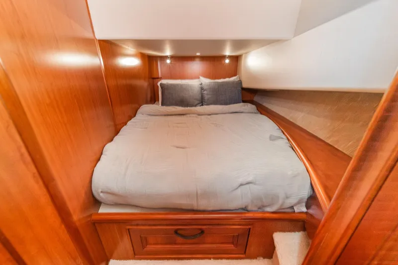Slide: The Image of Cozy bedroom in 2011 Mainship 395 Trawler with wooden paneling and soft lighting. - 58