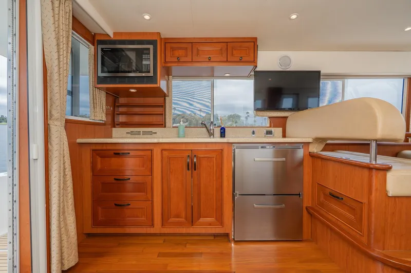 Slide: The Image of Interior of 2011 Mainship 395 Trawler with wooden cabinetry, stainless appliances, and modern amenities. - 6