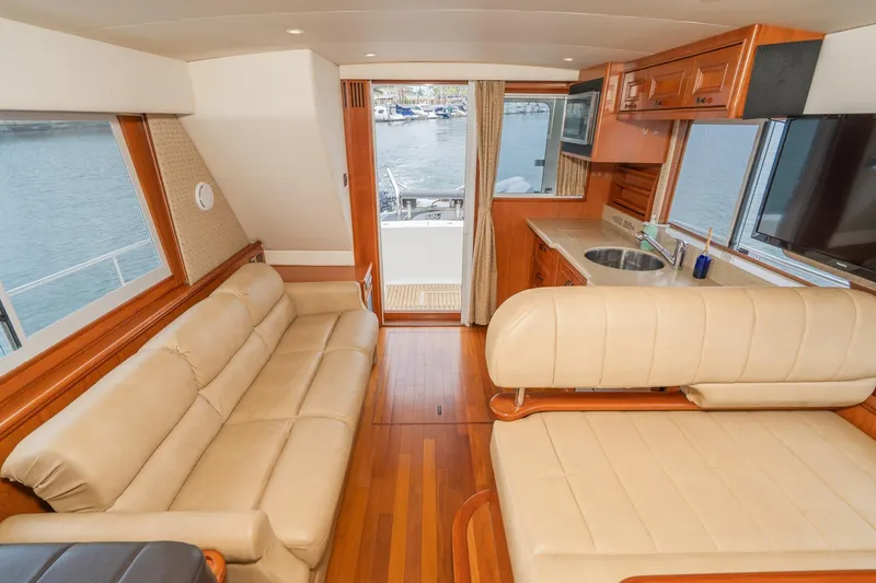 Slide: The Image of Interior of 2011 Mainship 395 Trawler with beige seating, kitchenette, and waterfront view. - 7