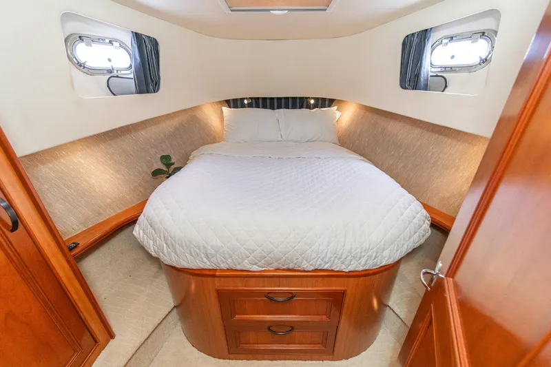 Slide: The Image of Cozy bedroom interior of 2011 Mainship 395 Trawler with elegant wood finish and soft lighting. - 8