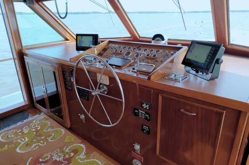 Slide: The Image of Helm of 1980 Hatteras 70 Motor Yacht with classic wooden dashboard and modern navigation equipment. - 1