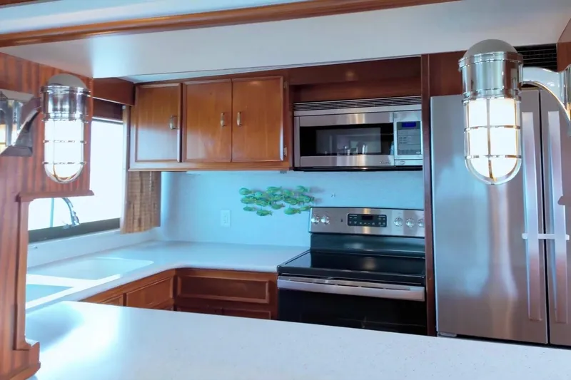 Slide: The Image of Kitchen interior of 1980 Hatteras 70 Motor Yacht with modern appliances and wooden cabinetry. - 11