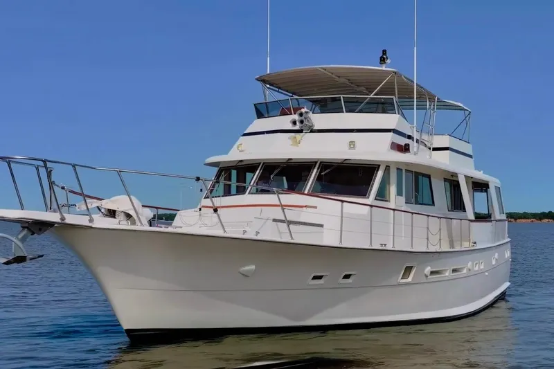 Slide: The Image of 1980 Hatteras 70 Motor Yacht on calm water under clear blue sky. - 2