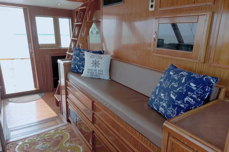 Slide: The Image of Interior of 1980 Hatteras 70 Motor Yacht with wooden decor and nautical-themed cushions. - 3