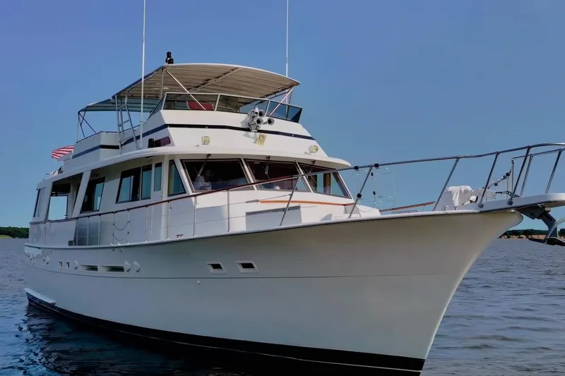 Slide: The Image of 1980 Hatteras 70 Motor Yacht cruising on calm waters under clear blue sky. - 6