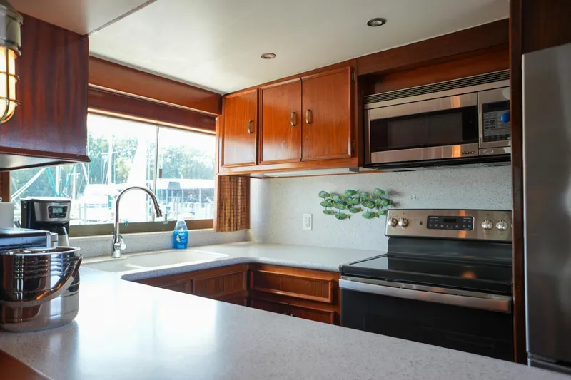 Slide: The Image of Interior kitchen of 1980 Hatteras 70 Motor Yacht with modern appliances and wooden cabinetry. - 8