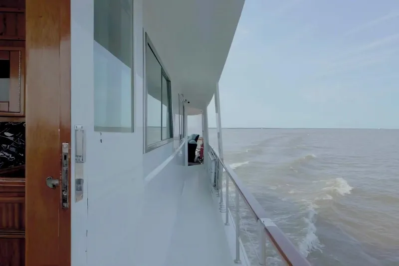 Slide: The Image of Side view of 1980 Hatteras 70 Motor Yacht cruising on open water. - 9