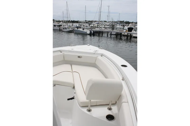 Slide: The Image of 2022 Sea Hunt Ultra 219 boat interior at marina, showcasing seating and docked boats. - 13