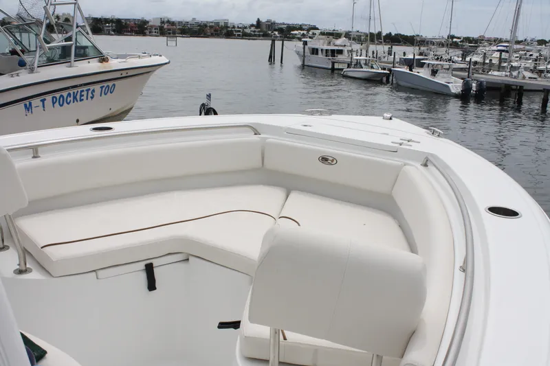 Slide: The Image of 2022 Sea Hunt Ultra 219 boat with spacious seating at a marina. - 15