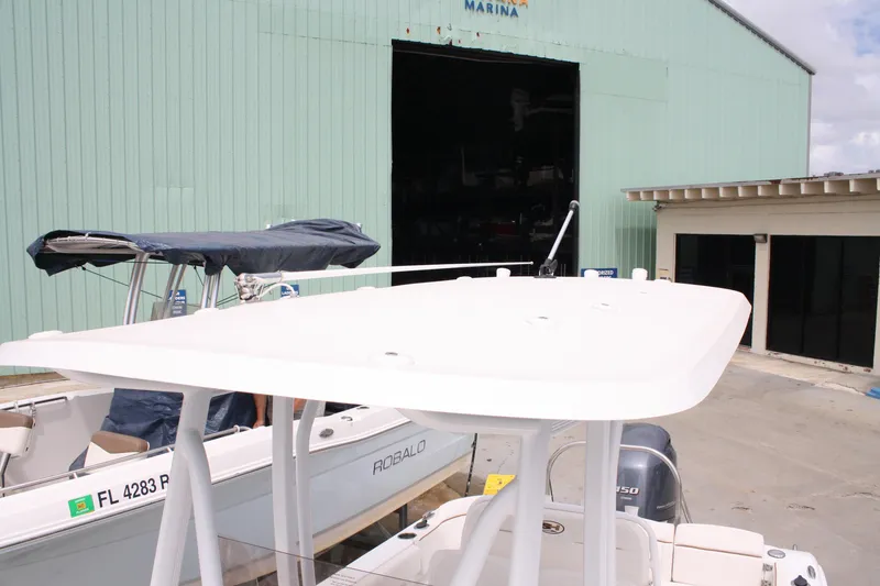 Slide: The Image of 2022 Sea Hunt Ultra 219 boat docked near a marina building. - 18