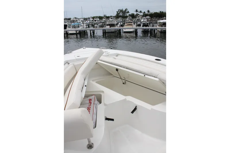 Slide: The Image of 2022 Sea Hunt Ultra 219 boat interior with open storage compartment at marina. - 21