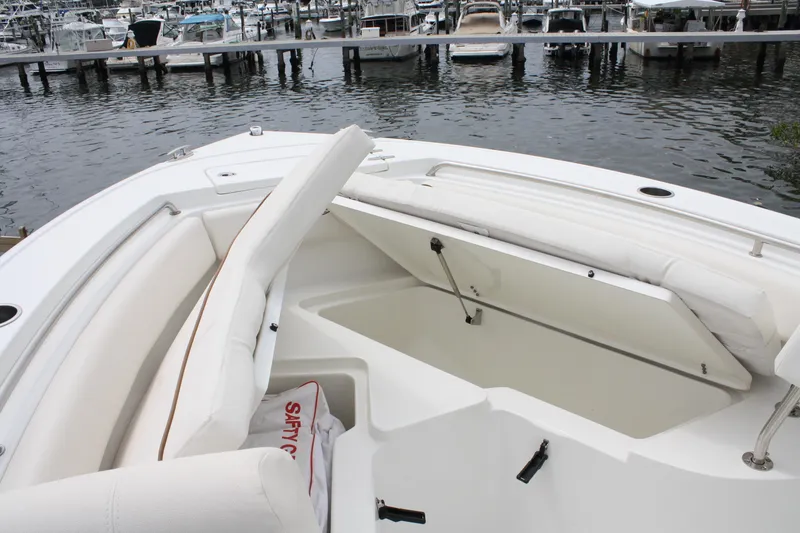 Slide: The Image of 2022 Sea Hunt Ultra 219 boat with open storage compartment at marina. - 22