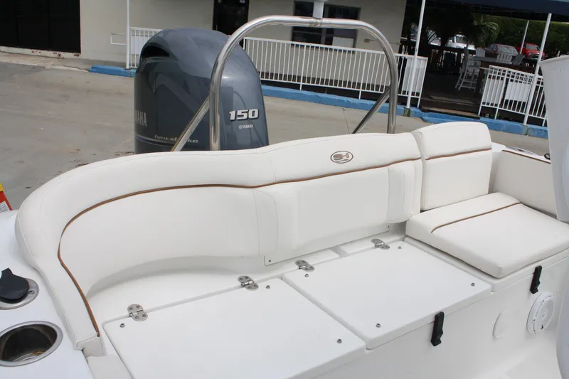 Slide: The Image of 2022 Sea Hunt Ultra 219 boat interior with Yamaha 150 engine, featuring white cushioned seating. - 24
