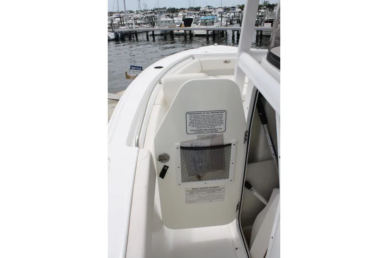 Slide: The Image of 2022 Sea Hunt Ultra 219 boat interior with storage compartment and safety notices. - 28