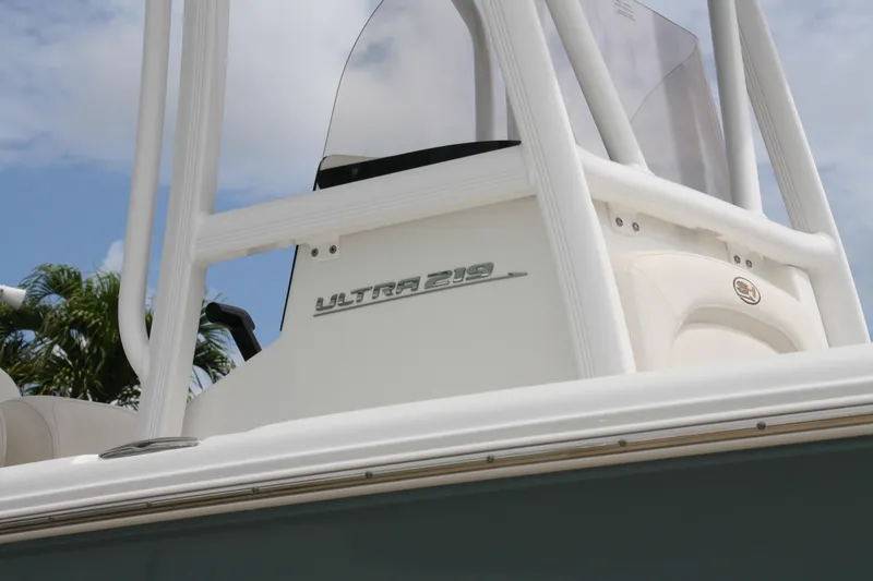 Slide: The Image of 2022 Sea Hunt Ultra 219 boat detail with logo, white structure, and clear sky background. - 3